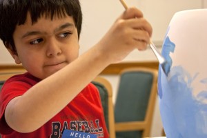 boy painting a vase
